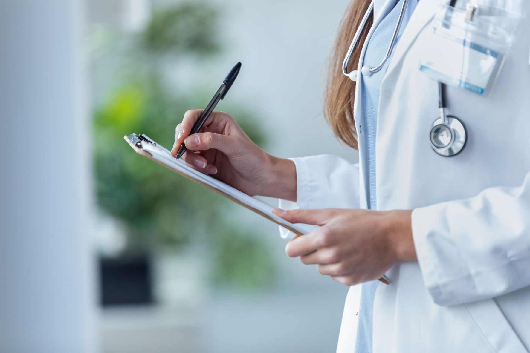 female-doctor-filling-up-medical-form-at-clipboard-2021-08-27-17-26-38-utc red