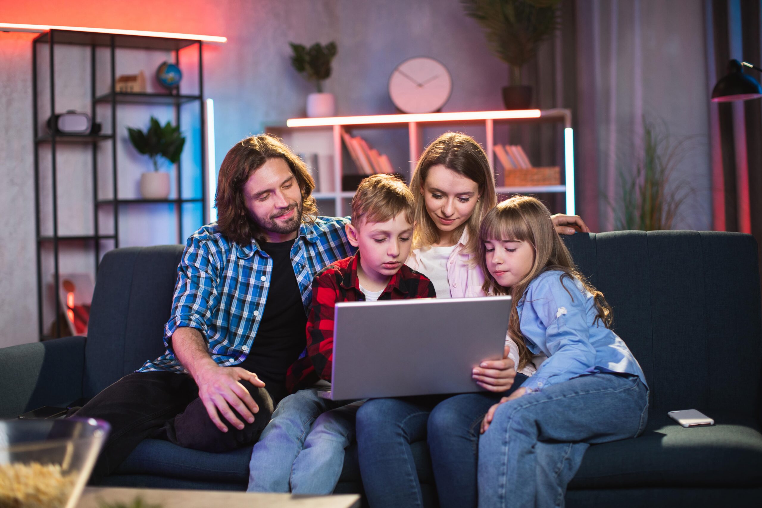 pleasant-family-sitting-on-couch-and-using-laptop-2021-09-04-10-34-18-utc-min